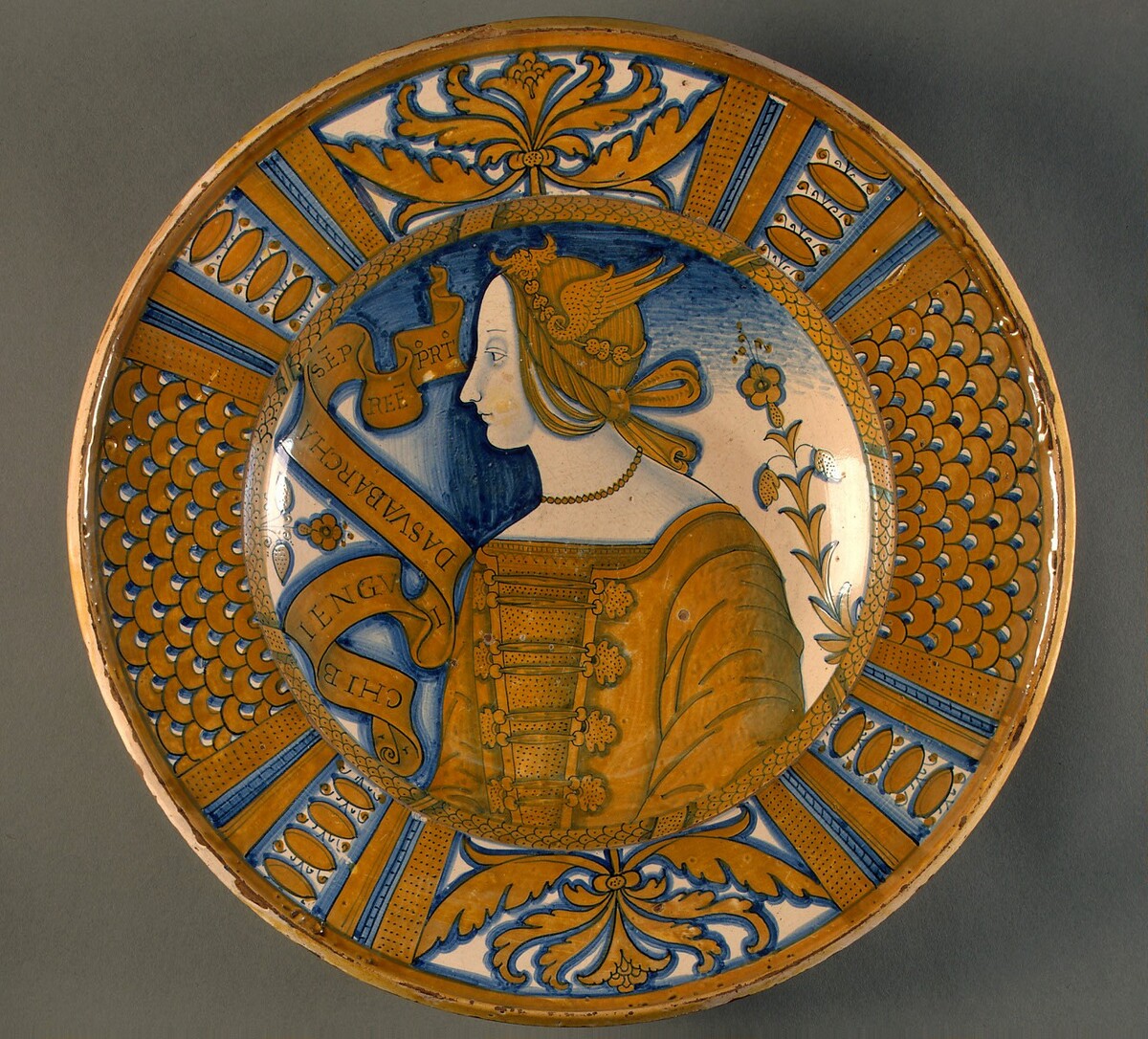 Large dish with segmental border of plant sprays and scale pattern; in the center, a profile bust of a woman in a winged headdress by Deruta 16th Century