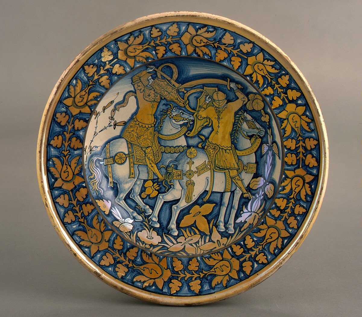 Large dish with running plant border; in the center, horsemen fighting by Deruta 16th Century